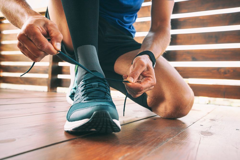 guypreparingforrunningandlacesuponthesneakers